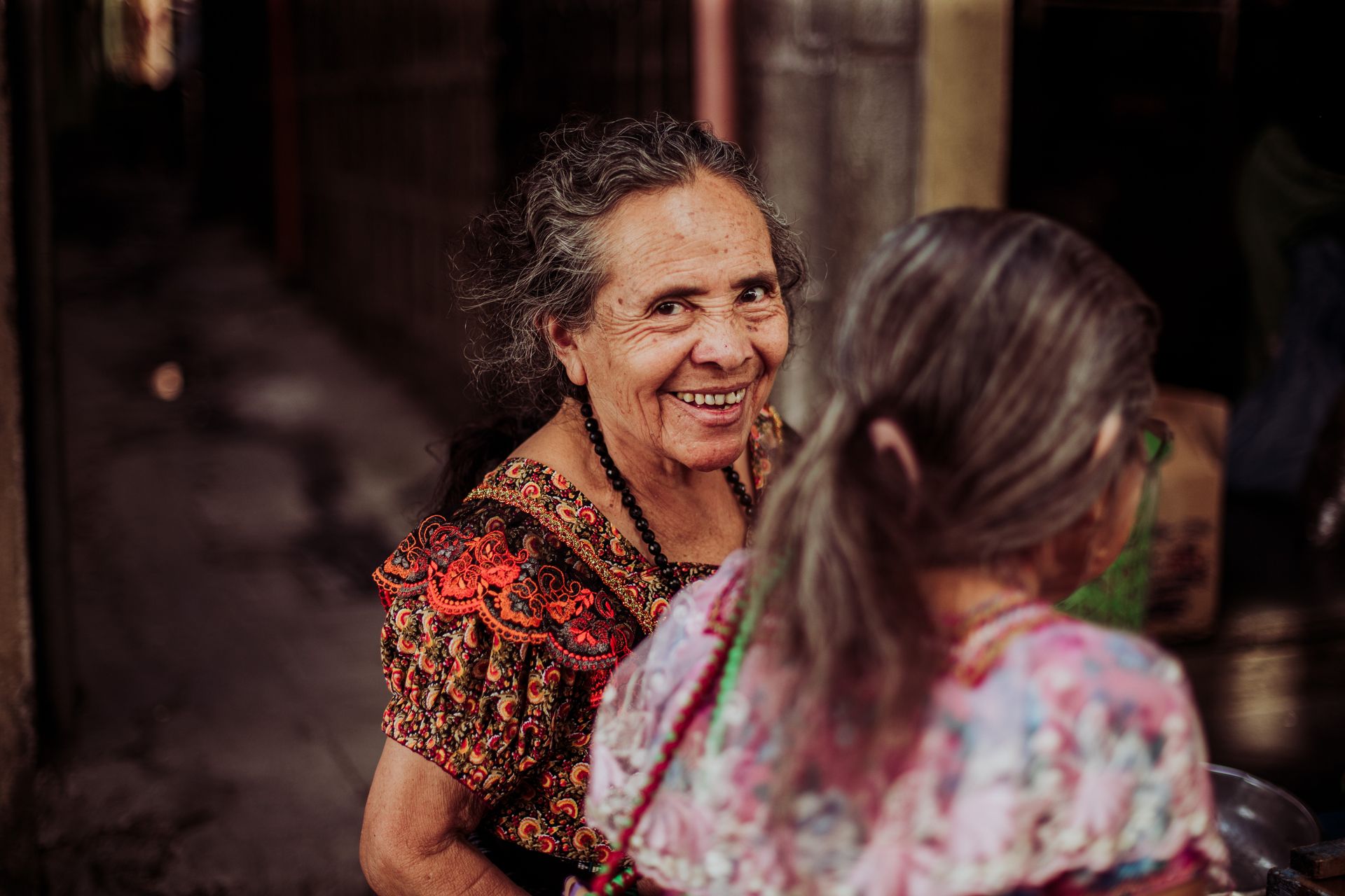 Mulheres em traje tradicional guatemalteco conversando — segurança comunitária